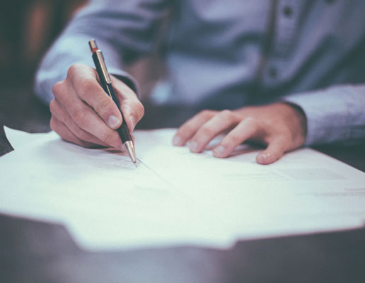 Image of guy holding pen, working